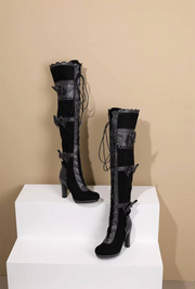 Front view of black Lolita high boots on display platform