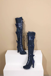 Pair of navy blue Lolita boots displayed with decorative bows and lace
