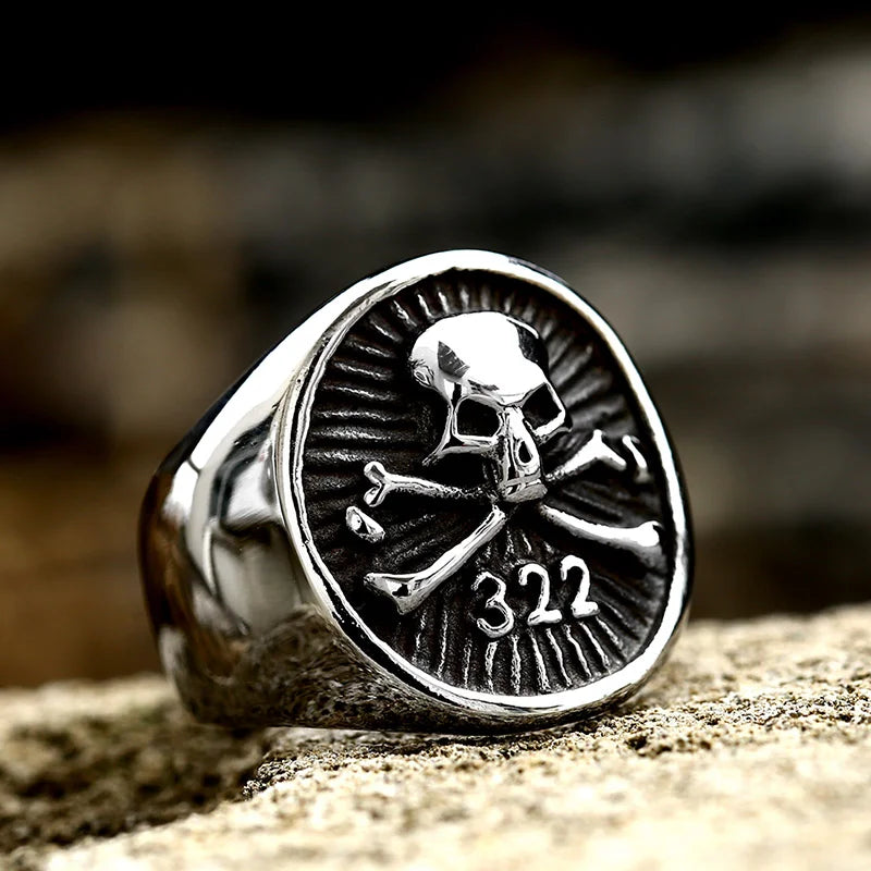 Front view of the Bones of the Forgotten ring made of stainless steel, showcasing a skull and crossbones with the number "322" engraved below.