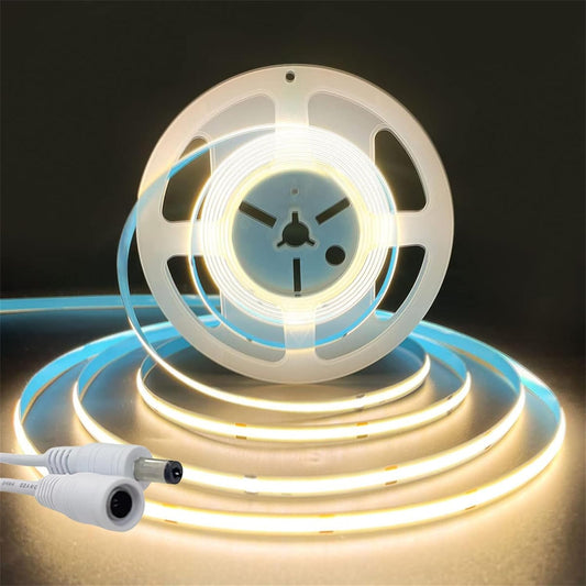 COB LED strip light roll emitting a warm white light with a close-up of the DC connector.