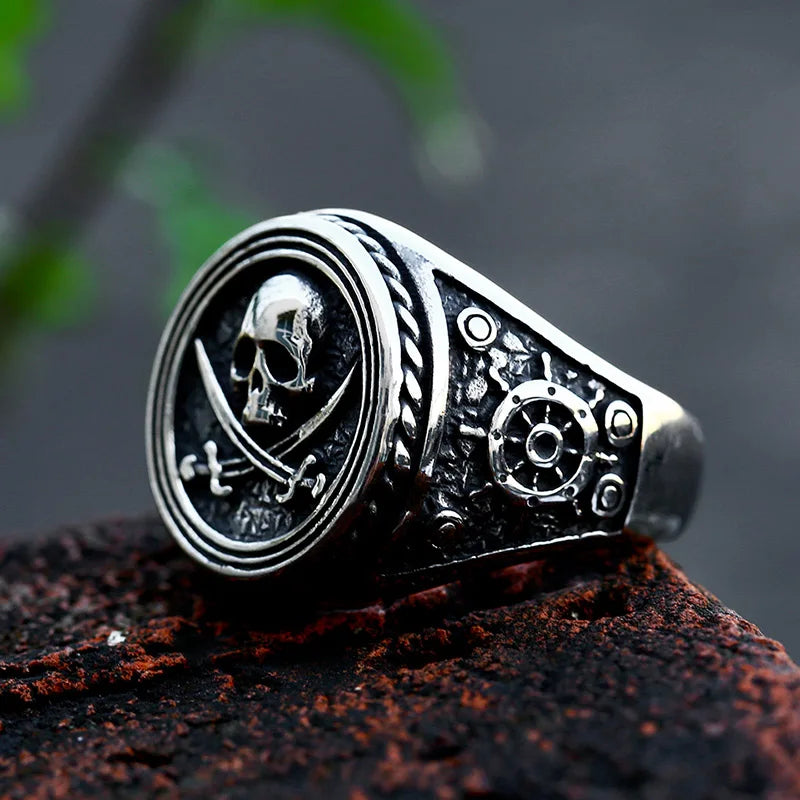 Close-up of The Captain's Oath ring focusing on the skull and crossed swords, accented by a ship's wheel design on the band.