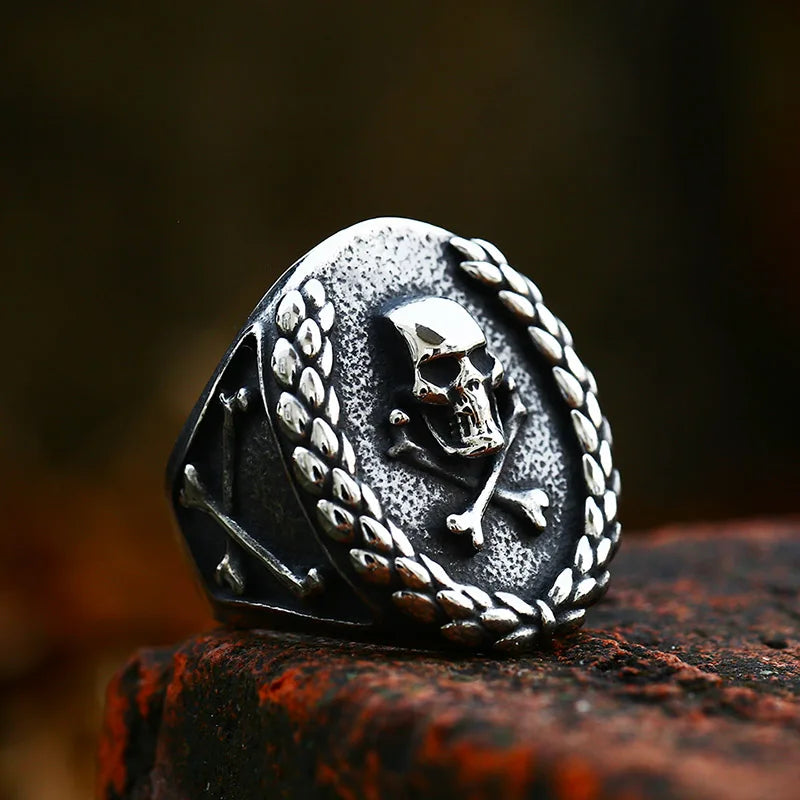 Angled side view of The Corsair’s Glory ring highlighting the skull design framed by a laurel wreath and intricate detailing on the band.