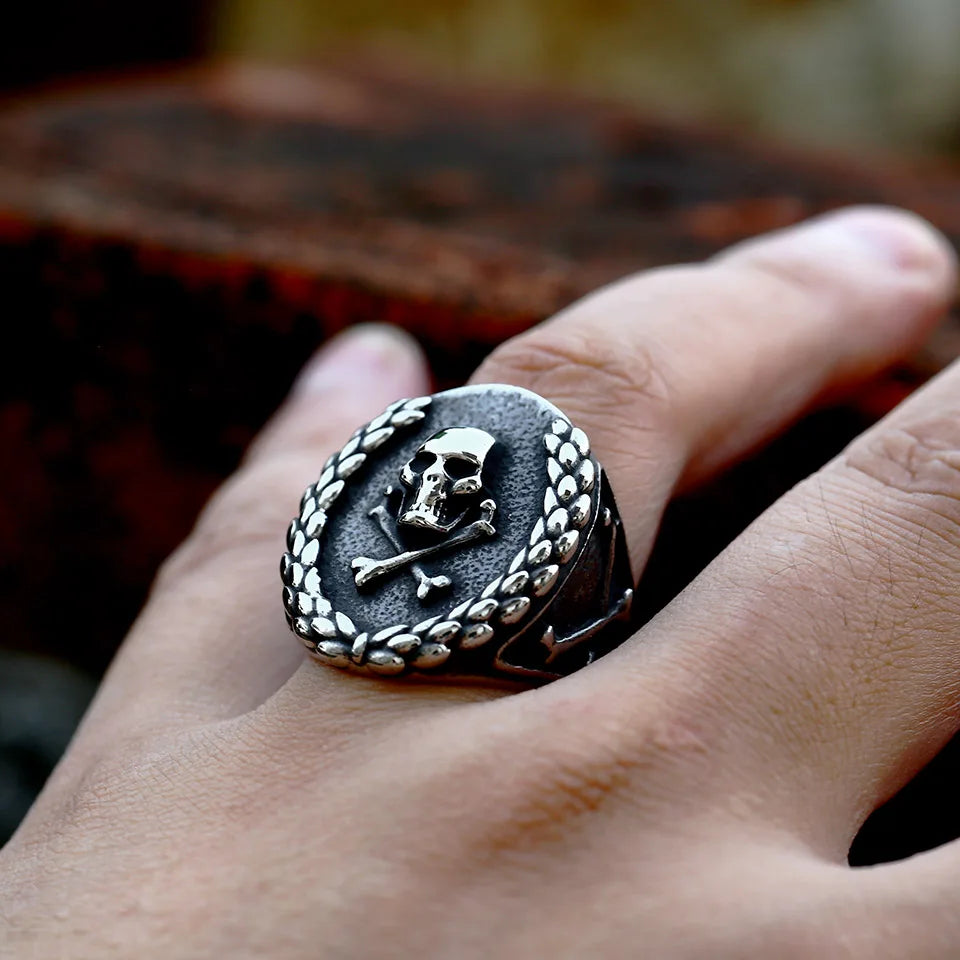 Close-up of The Corsair’s Glory stainless steel ring worn on a hand, showcasing the skull centerpiece surrounded by a laurel wreath.