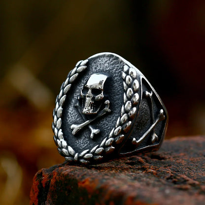 Front view of The Corsair’s Glory ring with a detailed skull and crossbones design encircled by a laurel wreath.