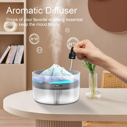 Snowy Mountain Humidifier being used as an essential oil diffuser, with a hand adding essential oil drops into the water.