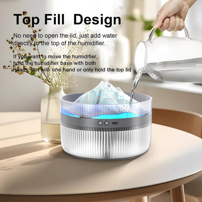 Top fill feature of the Snowy Mountain Humidifier being demonstrated by pouring water directly into the humidifier on a tabletop.