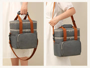 Woman holding and wearing the dual-layer lunch bag with shoulder strap.
