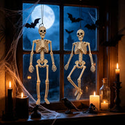 Two hanging Halloween skeletons displayed indoors with spooky decorations