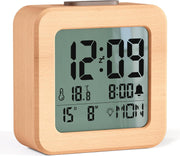 Close-up of wooden alarm clock LCD display showing time temperature and date