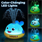 Color-changing LED whale sprinkler bath toy glowing in water
