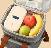 Open insulated lunch bag filled with apple, banana, pear, and a bento box.