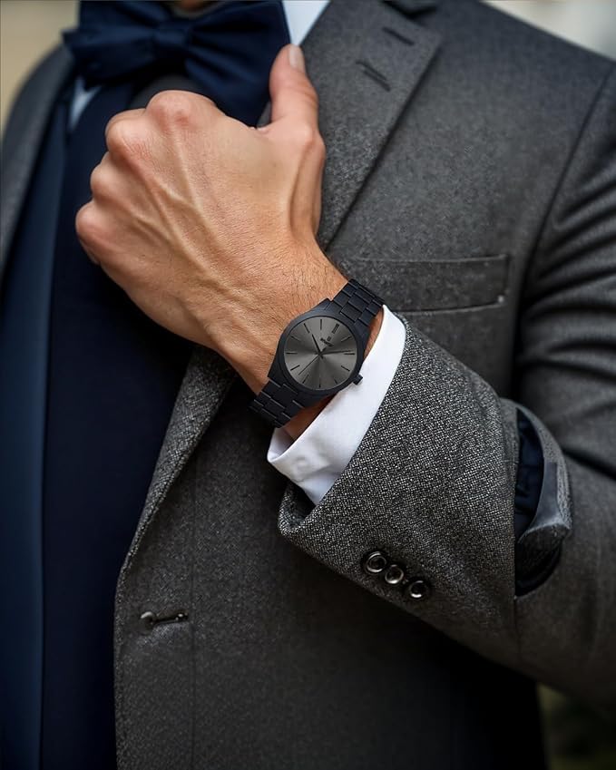 Elegant men's black wristwatch worn with formal grey suit