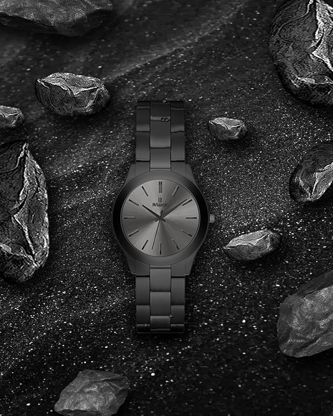 Black quartz watch displayed on a textured rocky black surface