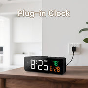 Plugged-in clock on a nightstand showing date, temperature, and time