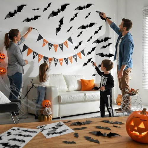 Family decorating a wall with reusable 3D black Halloween bat decorations for a party