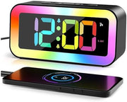 Modern RGB digital alarm clock beside a smartphone charging area