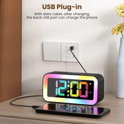 RGB digital alarm clock with USB charging port charging a smartphone