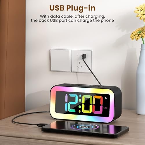 RGB digital alarm clock with USB charging port charging a smartphone