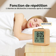 Wooden alarm clock with snooze function next to sleeping person