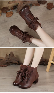 Brown PU leather ankle boots worn by model sitting on wooden floor.
